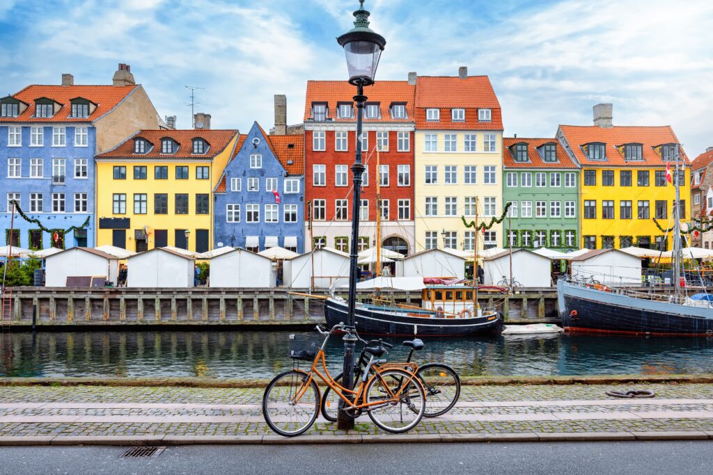 Copenhagan city with its multi colour houses and bikes laying next to a lamppost