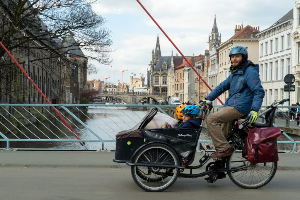 A family using a cargo bike or trailer to carry their kids in the city of Ghent